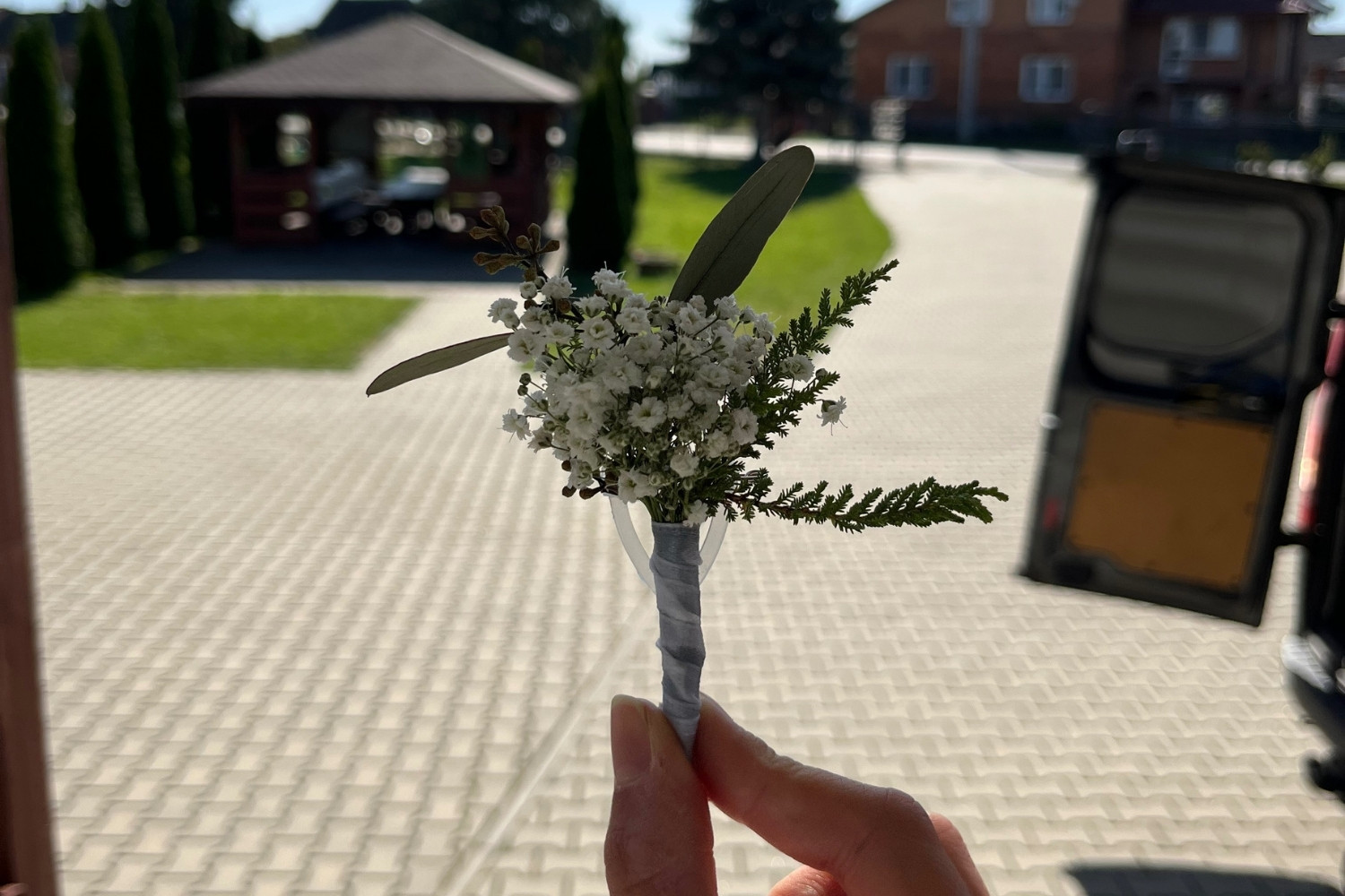 Minimalistyczna butonierka weselna z gipsówki i gałązką oliwną